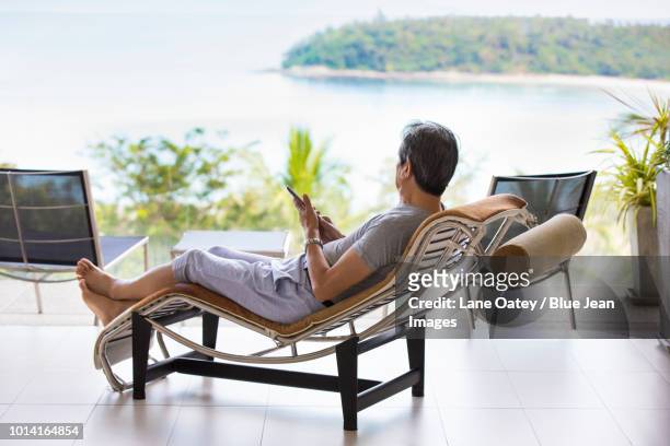 happy senior man relaxing on balcony - beach house balcony fotografías e imágenes de stock