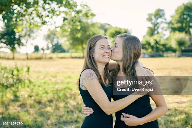 twin sisters - twin kiss stock pictures, royalty-free photos & images
