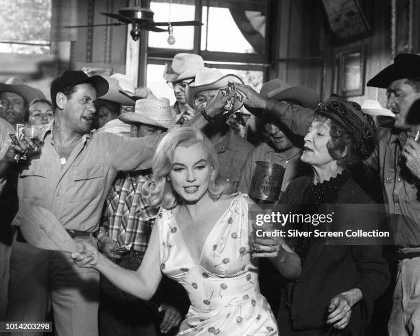 From left to right, actors Eli Wallach, Marilyn Monroe and Estelle Winwood in the paddle-ball scene from the film 'The Misfits', 1961.