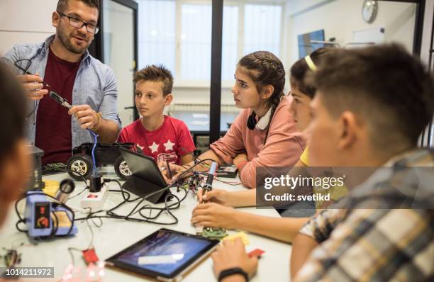 instructor helping students on electronic course - robot teacher stock pictures, royalty-free photos & images
