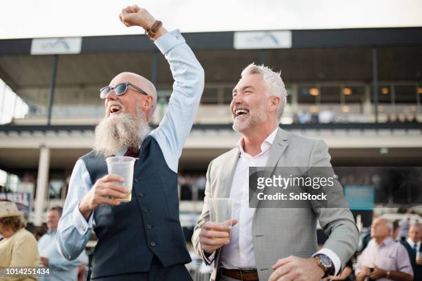 zwei männer feiern - pferderennen stock-fotos und bilder