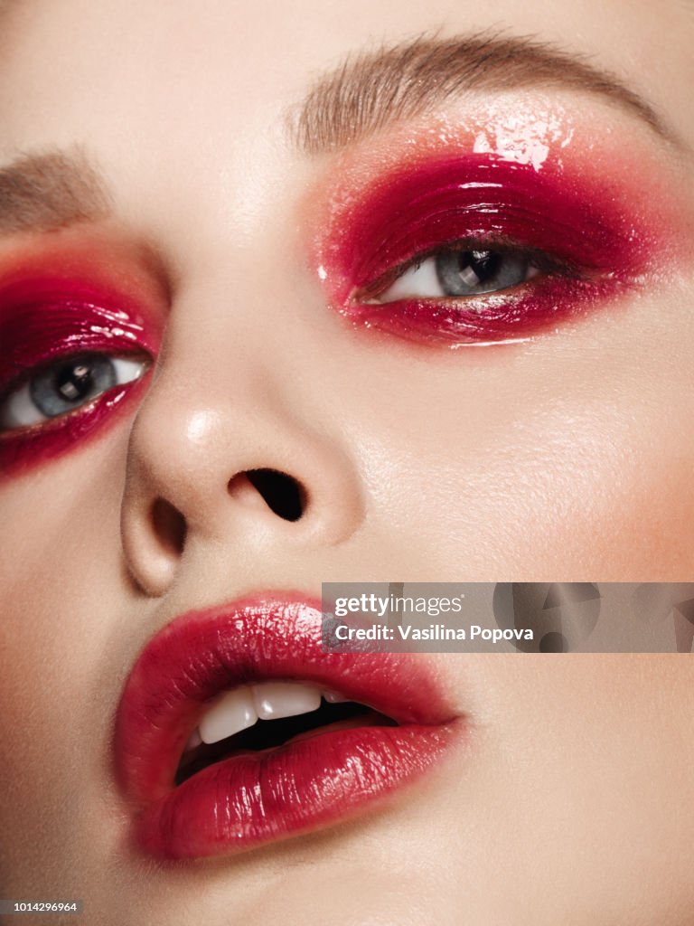 Beautiful woman with glossy red bright make-up