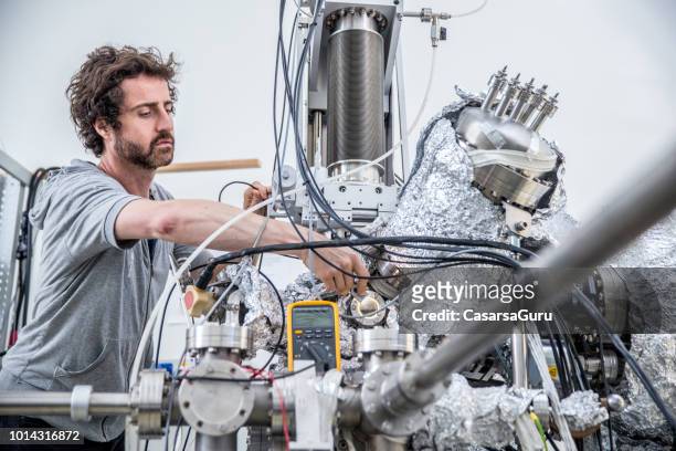 researcher analyzing new materials samples in airtight chamber for laser research - mason jar stock pictures, royalty-free photos & images