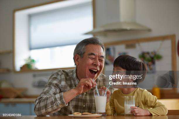 grandfather and grandson drinking milk - milk family stock pictures, royalty-free photos & images