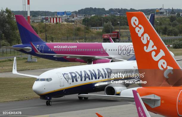 RyanAir passenger plane taxis past planes of other discount airliners Wizz Air and EasyJet at Schoenefeld Airport near Berlin during a 24-hour strike...
