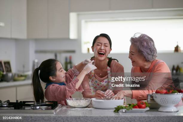 grandmother, mom and granddaughter enjoying cooking - asian mother cooking imagens e fotografias de stock