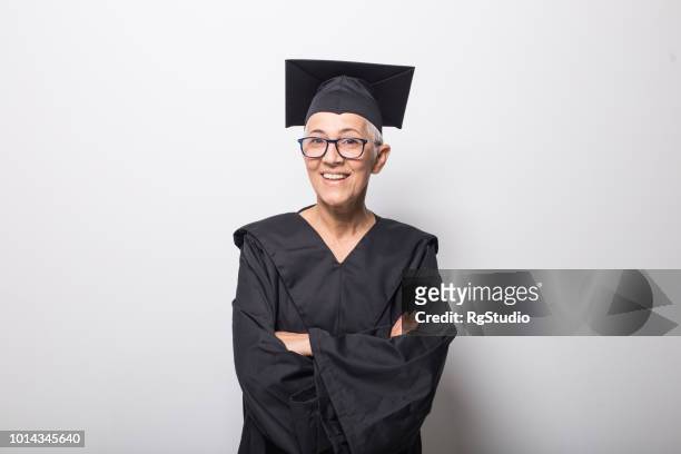 feliz mujer senior con mortarboard - graduation gown fotografías e imágenes de stock