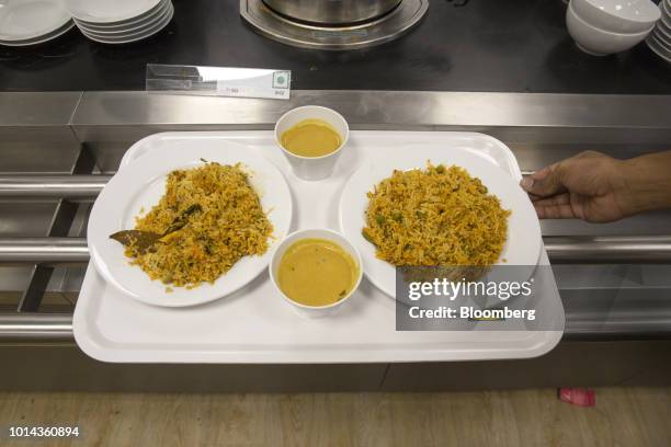 Plates of biryani rice sit next to bowls of soup on a tray in the restaurant of the Ikea store in Hitech City on the outskirts of Hyderabad, India,...