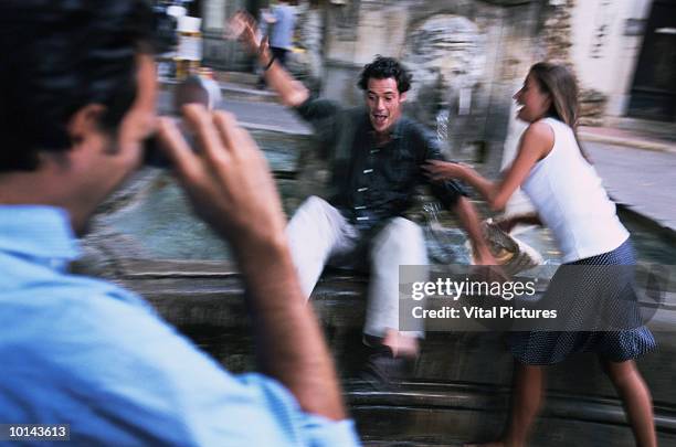 couple having photo taken by fountain - northern european descent stockfoto's en -beelden