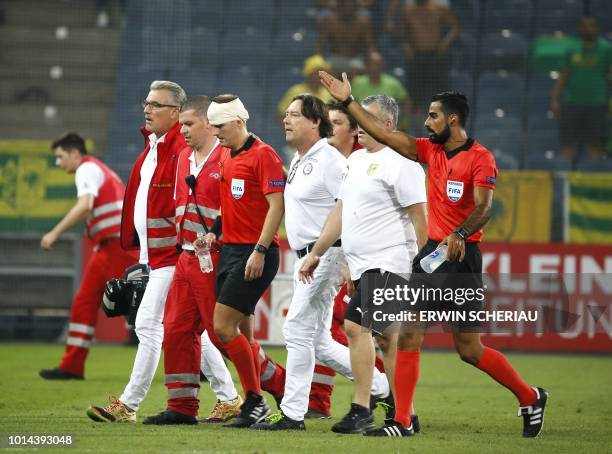 Assistant Referee Fredrik Klyver leaves the field after he got hit by a cup during the UEFA Europa League qualifying football match between SK...