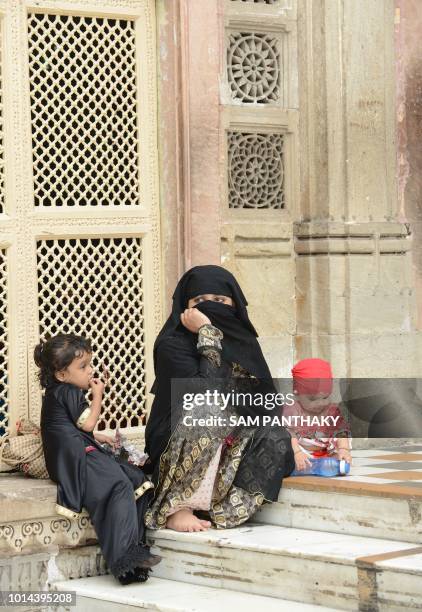 An Indian Muslim woman sits with two children at the Shah-E-Alam Dargah in Ahmedabad on August 10, 2018. - Triple Talaq Bill has been deferred in the...