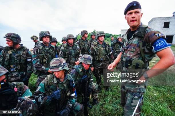 An unidentified Estonian army officer stand with US marines during a training exercise, Estonia, 1997. The officer is with the Baltic Brigade and the...