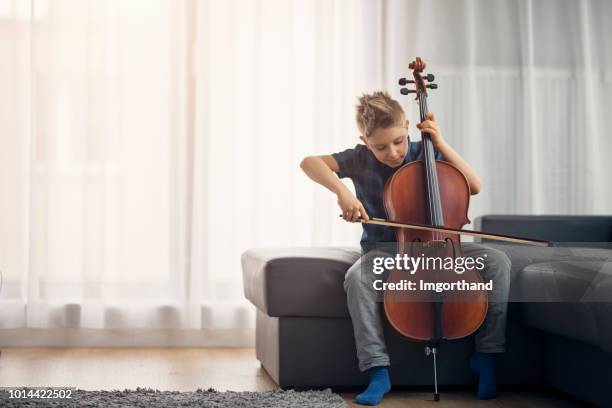 niño practicando en casa chelo - musical instrument string fotografías e imágenes de stock
