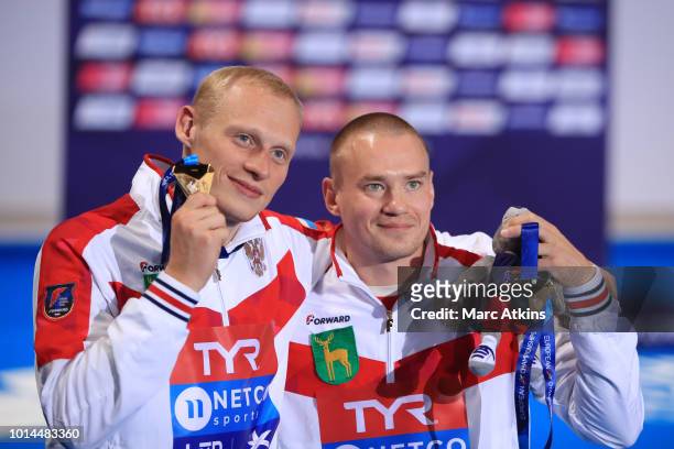 Evgenii Kuznetsov and Ilia Zakharov of Russia pose for a photo with their medals after winning the gold in Men's Synchronised 3m Springboard Final on...