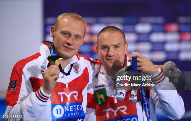 Evgenii Kuznetsov and Ilia Zakharov of Russia pose for a photo with their medals after winning the gold in Men's Synchronised 3m Springboard Final on...