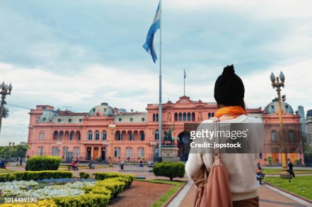 young woman walking at plaza de mayo square in buenos aires, argentina - casa rosada foto e immagini stock