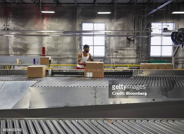 An employee sorts packages for delivery at the FedEx Corp. Ground distribution center in Jersey City, New Jersey, U.S., on Tuesday, Aug. 7, 2018....