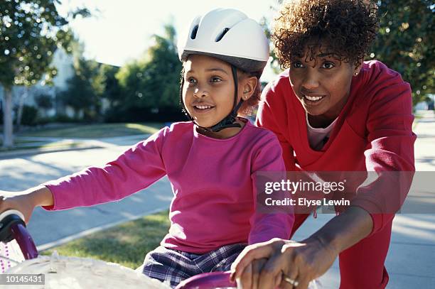black girl learning to ride bike - bicycle daughter stock-fotos und bilder