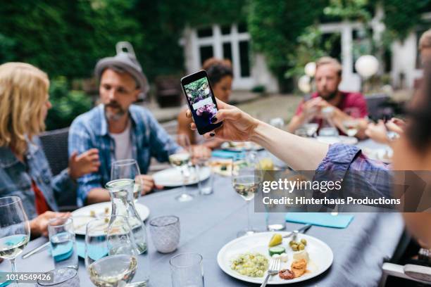 friends taking a selfie together during outdoor meal - dinner jacket stock-fotos und bilder