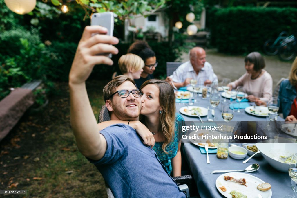 Couple Taking Selfie During BBQ With Family
