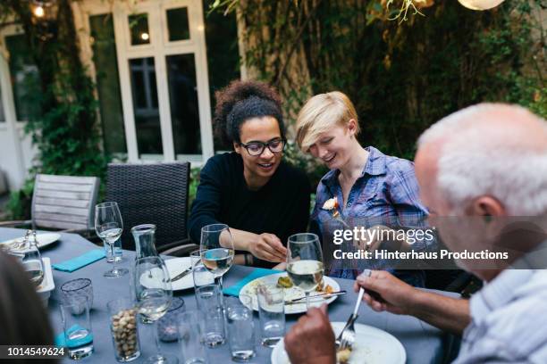 Friends Sharing Food During Meal With Family