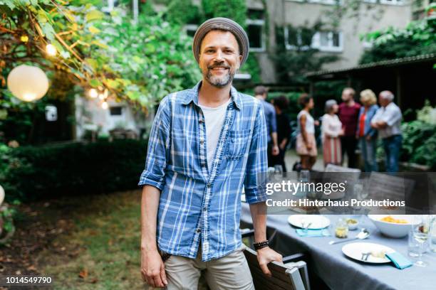 portrait of man smiling during family bbq - hemden stock-fotos und bilder