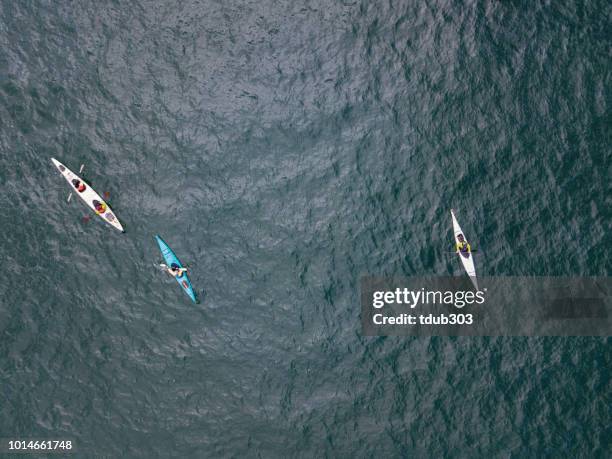 aerial shot of a small group of people sea kayaking - sea kayak stock pictures, royalty-free photos & images