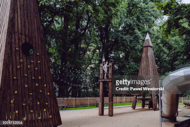 boy at public playground on monkey bars - krakow park stock pictures, royalty-free photos & images