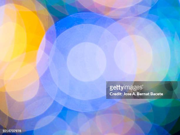 close-up abstract pattern of intertwined colorful light beams of color light blue, yellow and green on a  black background. - elipse imagens e fotografias de stock