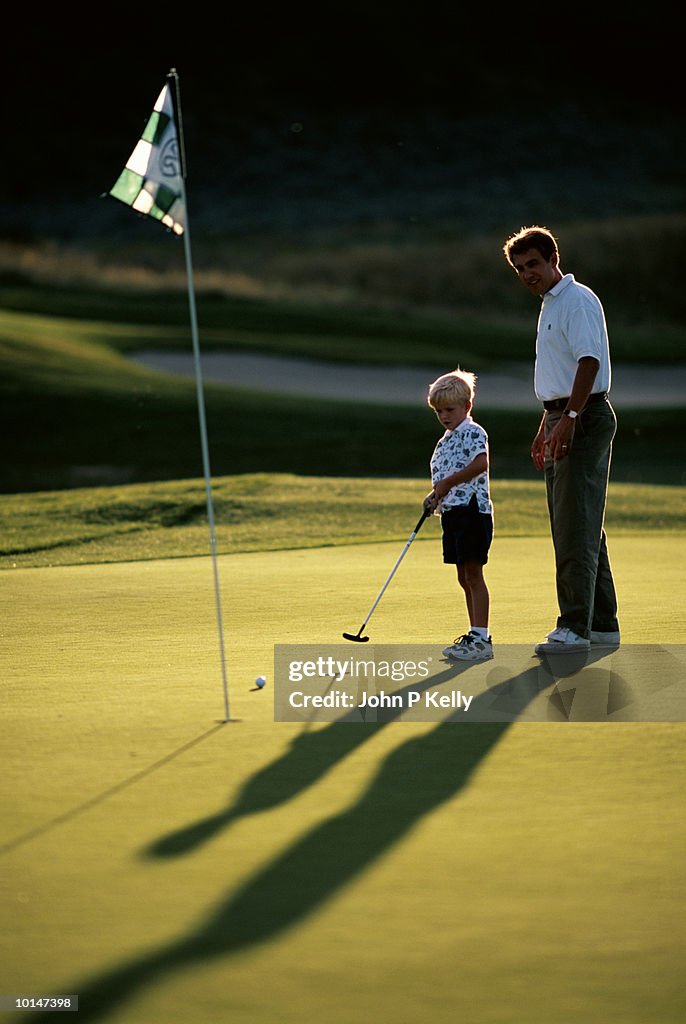 GOLF LESSON, FATHER AND YOUNG SON