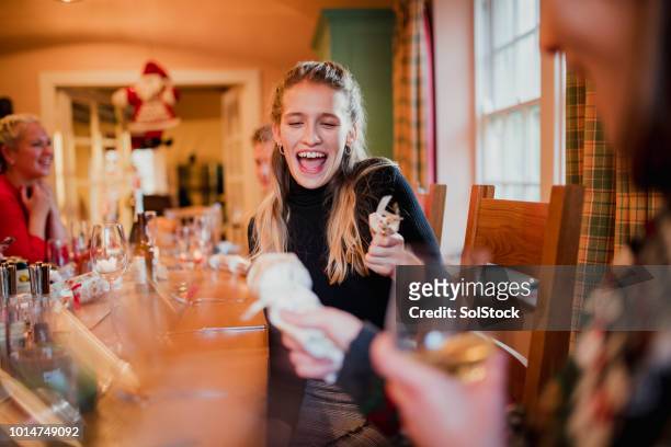 pulling christmas crackers before dinner - christmas crackers stock pictures, royalty-free photos & images