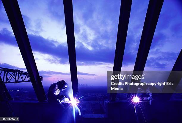 welders working on skyscraper, silhouette - last day stockfoto's en -beelden