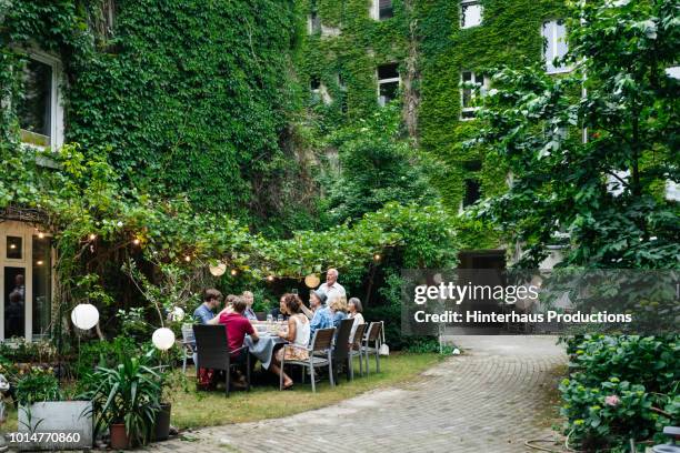 family enjoying an outdoor meal together - summer bbq stock pictures, royalty-free photos & images