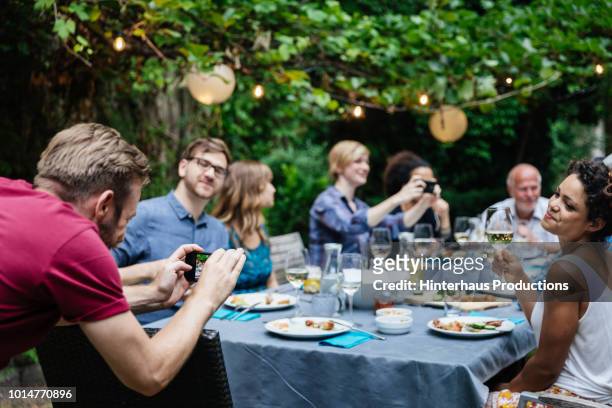man taking photo of friends at family bbq - barbecue social gathering stock pictures, royalty-free photos & images