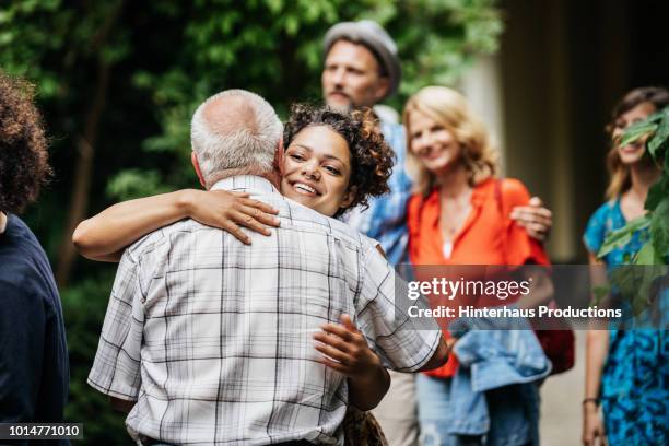 elderly man saying goodby to family after bbq - old man young woman stockfoto's en -beelden