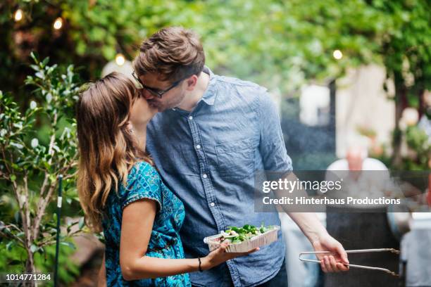 couple kissing while cooking at family bbq - young couple cooking stock pictures, royalty-free photos & images
