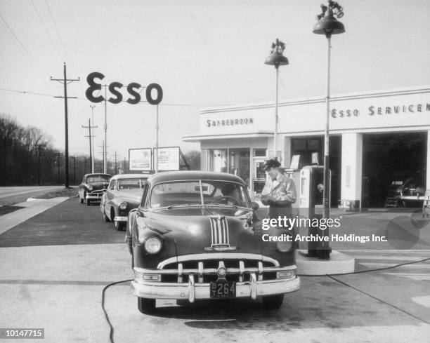 attendant at esso serving customer, circa 1949 - gasoline station stock pictures, royalty-free photos & images