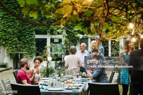 family eating together in courtyard - sitzplatz garten relax stock-fotos und bilder