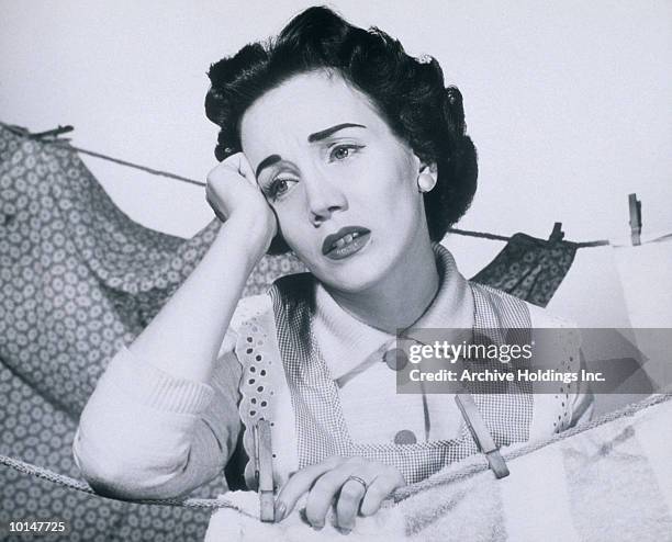anguished housewife hanging clothes - 1950 females only housewife stock pictures, royalty-free photos & images