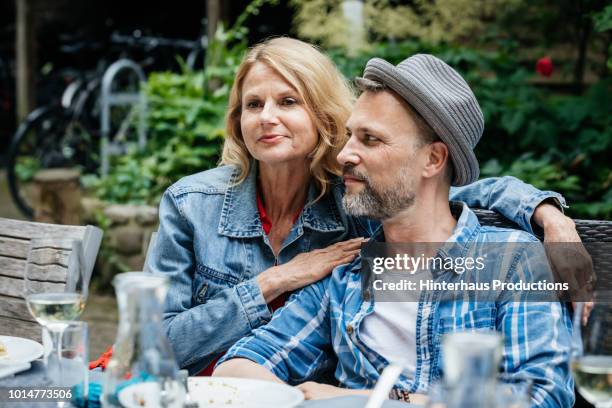 couple sitting together at family bbq - heteroseksueel koppel stockfoto's en -beelden