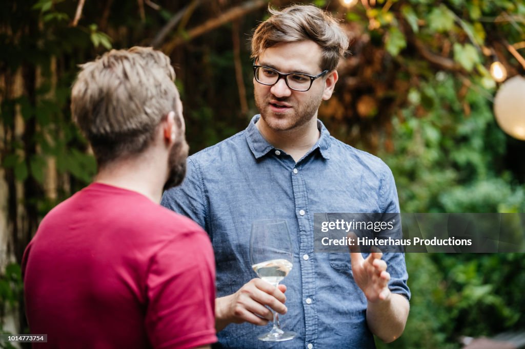 Two Friends Chatting And Drinking At BBQ