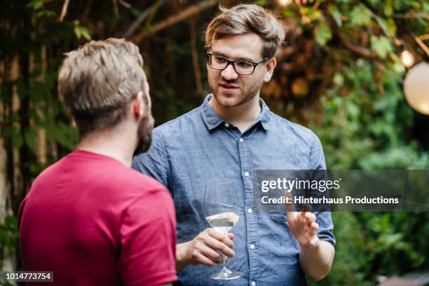 two friends chatting and drinking at bbq - two people standing stock pictures, royalty-free photos & images