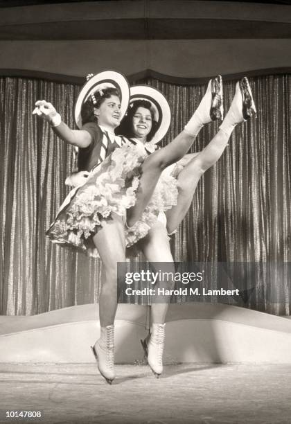 WOMEN IN ICE SKATES LEGS KICKED UP, 1930S