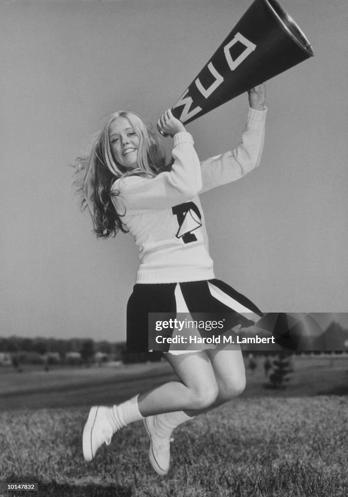 CHEERLEADER JUMPING, HOLDING MEGAPHONE