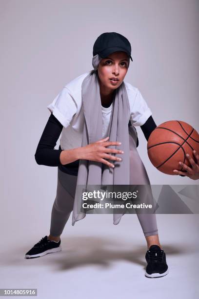 muslim woman playing basketball - islamic action front stock pictures, royalty-free photos & images