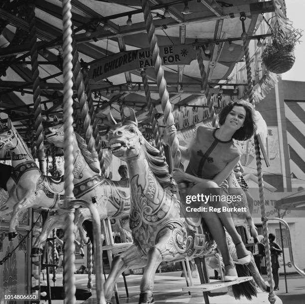 British actress Gabrielle Drake riding a carousel horse, UK, 12th August 1969.