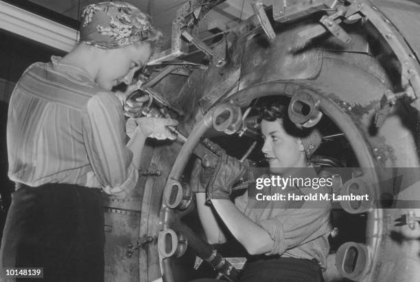 FEMALE FACTORY WORKERS RIVET AN AIRPLANE, WORLD WAR II