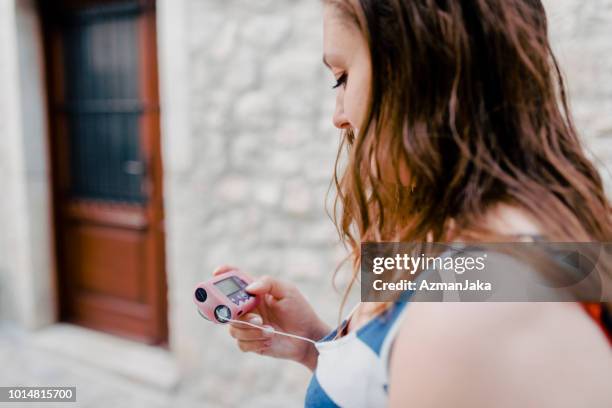 young diabetic woman holding an insulin pump in the city - insulin pump stock pictures, royalty-free photos & images