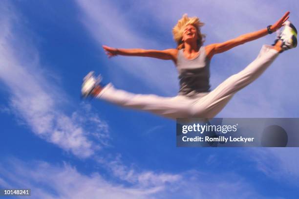 young blonde woman jumping, happy, fun - doing the splits stock pictures, royalty-free photos & images