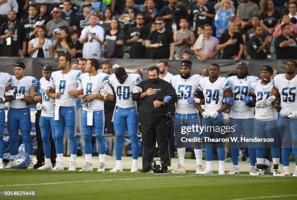 Head coach Matt Patricia of the Detroit Lions interlock arms with his players during the National Anthem prior to the start of an NFL preseason...